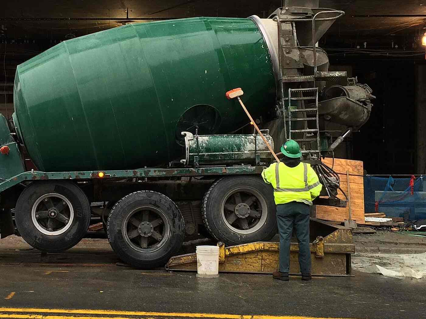 The drum of a mixer truck being hosed down at a site entrance
